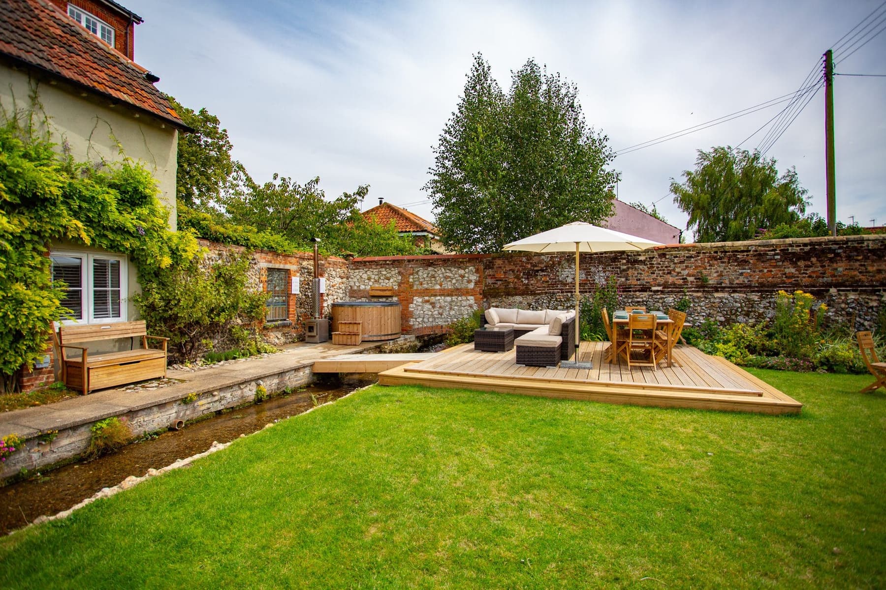 Walled garden at South Creek Retreat with decked terrace and hot tub