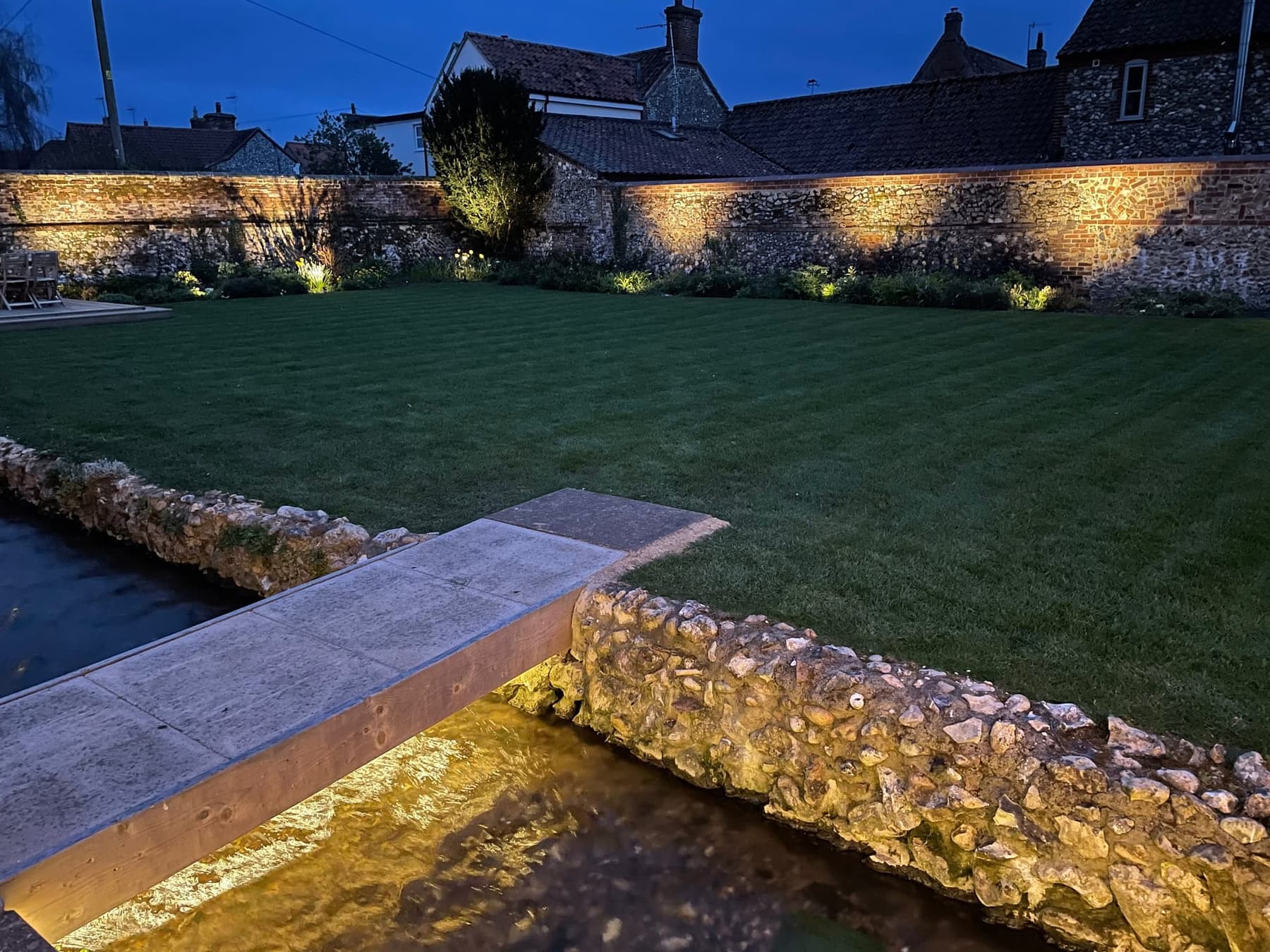 The walled lawn at South Creek Retreat lit at dusk