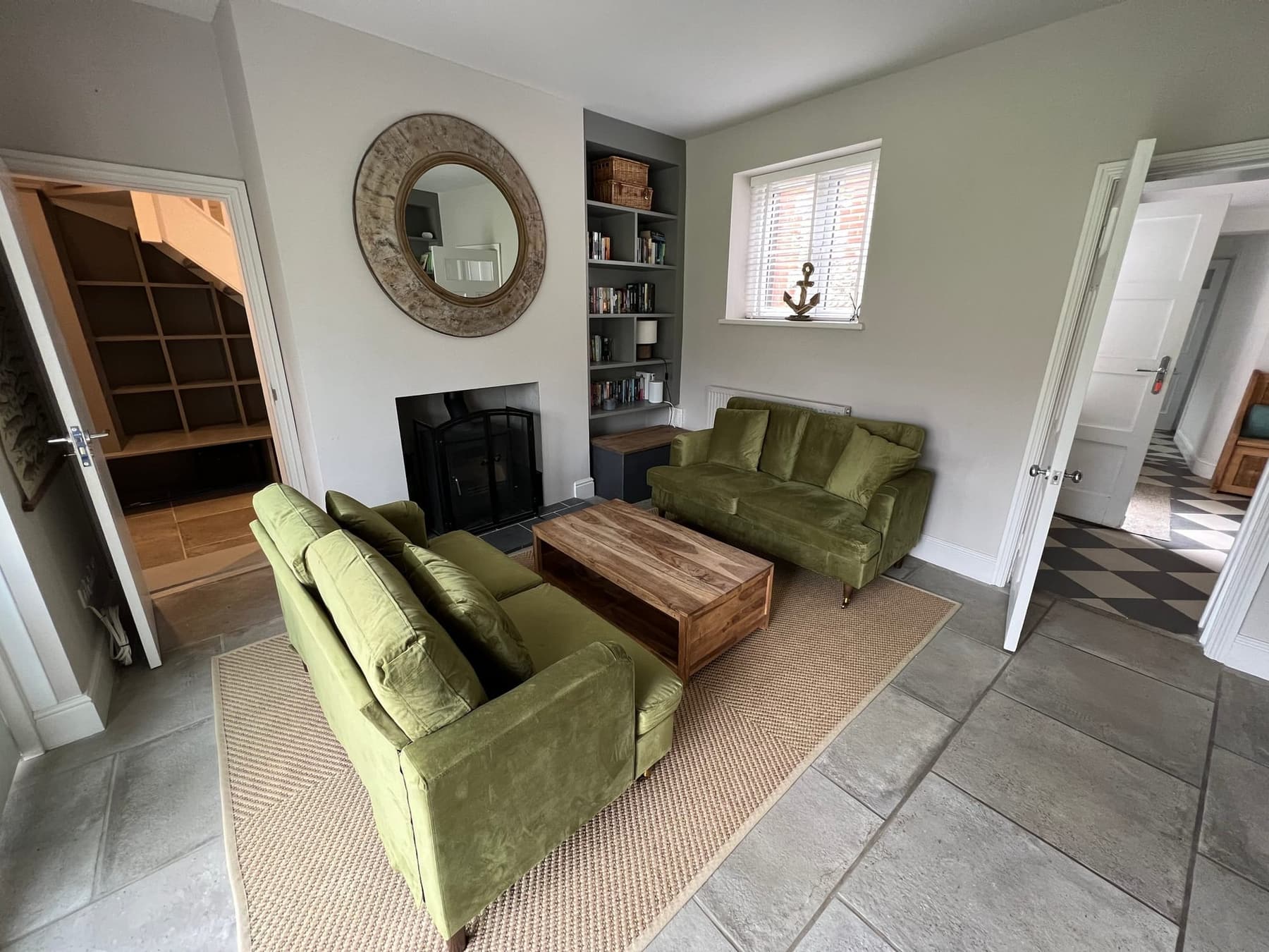 The log burner beneath the round mirror in the lounge